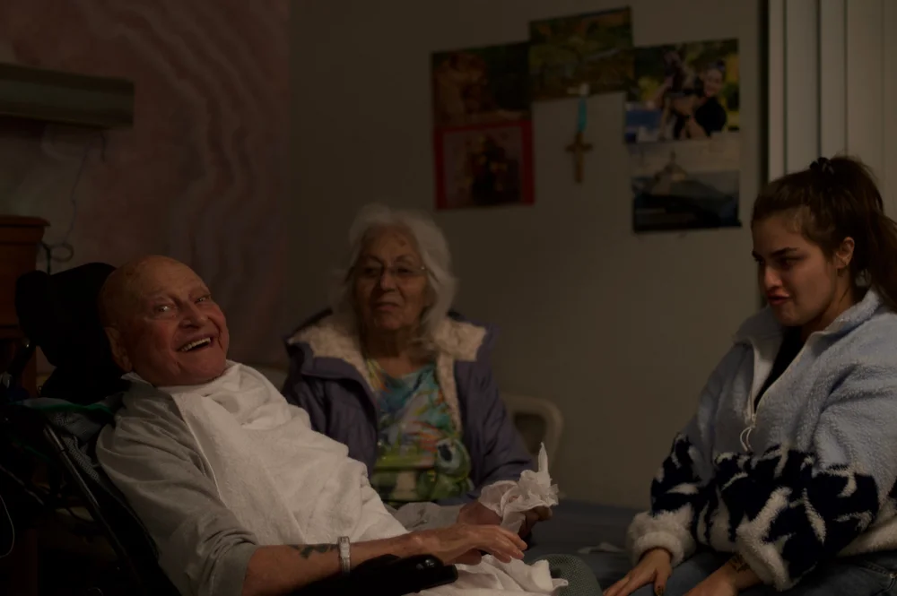 Three people sitting together in a living room.